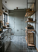 Kitchen with grey cupboards and open shelving made of wood and metal