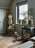 Vintage bedroom with dressmaker's dummy and large vase on console table