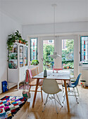 Dining area with wooden table, bench, chairs and colourful rug
