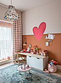 Playroom with heart wall decoration, wooden desk and carpet