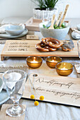 Table setting with pretzels, candle bowls and personalised wooden boards