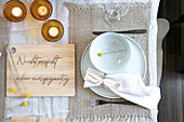 Set dining table with message on wooden board and candle lights