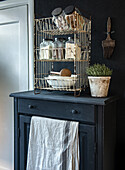 Black chest of drawers with wire basket and spice containers