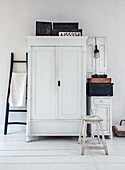 White vintage cupboard with decorations in a minimalist room