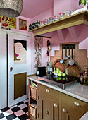 Retro kitchen with pink walls and black and white chequered floor