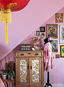 Bedroom with vintage wooden furniture, Asian lantern and gallery wall