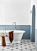 Freestanding bathtub in bathroom with two-toned walls