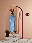 Hallway with arched passageway and vintage dress on coat rack