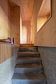 Staircase with concrete steps and walls made of light-coloured wood