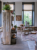 Living area with wooden room divider, rattan armchair and patterned rug