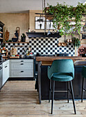 Kitchen with chequerboard tiles, cooking island and velvet bar stool