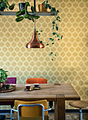 Dining area in front of yellow patterned wallpaper