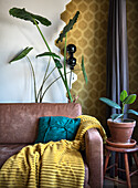 Leather sofa and indoor plants in front of a mustard yellow honeycomb wall