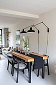 Dining area with wooden table, black chairs and modern wall lights