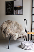 Chair with sheepskin and modern wall art