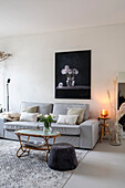 Living room with grey sofa, rattan table and artwork above the couch