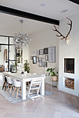 Dining room with white wooden table, designer lamp and wall art gallery