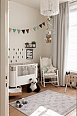 Bright children's room with cot, toys and bunting garland