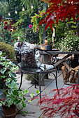 Gemütliche Terrasse mit Sitzgelegenheit, Kerzenlicht und herbstlicher Bepflanzung