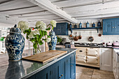 Country-style kitchen with blue cabinets and white flowers