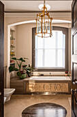 Bathroom with wood paneling and gold-toned hanging lamp