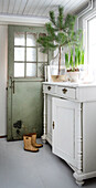 Antique white cupboard in the hallway, wellies and plant decoration