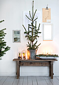 Wooden table with Advent decorations, candles and Christmas tree in a zinc bucket