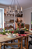 Festive dining table with candlesticks and shelf with rustic decorations