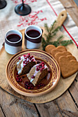 Christmas cake with cranberries and mulled wine on a rustic wooden table