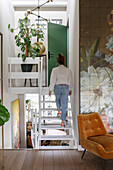 Open staircase leads to green door with large floral wall design