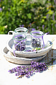 Lavender flowers in preserving jars on ceramic bowls on a table in the summer garden