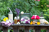 Natural cosmetics and flower arrangement on rustic wooden table in the garden