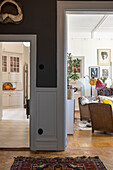 View from hallway into living room with rattan chairs and vintage furniture