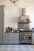 Kitchen with tiled backsplash, gas oven and light grey cabinets