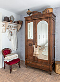 Antique wooden wardrobe with mirrors and vintage-style coat hook rail