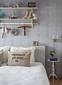 Bedroom with wall shelf, small side table and vintage decorative objects