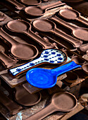 Traditional glazed ceramic spoons in blue and white on clay blanks