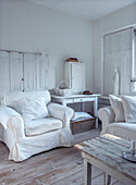 Bright living room with white vintage furniture and wooden floorboards