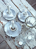 Antique white candlesticks and glass candle holders on a shabby chic wooden table