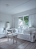 White living room with vintage furniture and light-colored wooden floor