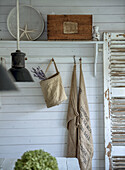 Linen bag and bouquet of lavender on wall hooks in rustic country house style