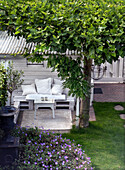 Garden seating area with white wooden bench surrounded by plants