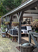 Covered terrace with wooden furniture and plants