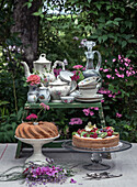 Coffee table in the garden with china crockery, Gugelhupf and fruit cake