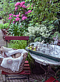 Garden table with various crockery and a basket full of lace and yarn