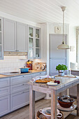 Light country kitchen with light grey cabinets and kitchen island