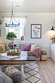 Cosy living room with wooden table, grey corner sofa and floral decorations