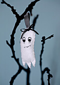 Homemade felt ghost as a Halloween decoration on a branch