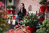 Woman drinking coffee on autumn terrace