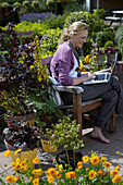 Frau sitzt auf Gartenbank
